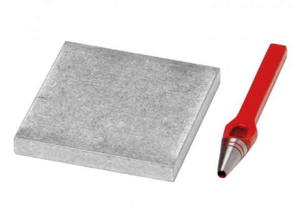 Auf dem Bild ist ein graues, quadratisches Metallstück und ein roter Bleistift mit einer spitz zulaufenden Mine zu sehen. Der Kontrast zwischen dem glatten Metall und dem farbigen Stift ist auffällig.