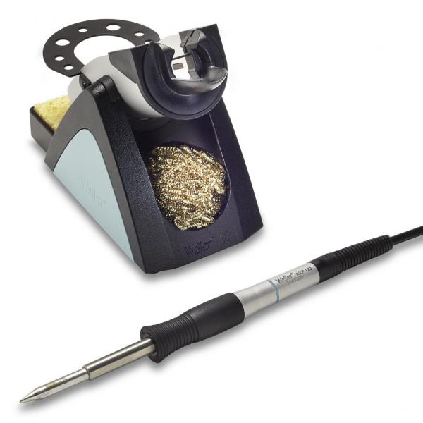 Das Bild zeigt einen Lötkolben mit einem Elektrokabel und einem Lötgerät. Das Gerät hat eine rechteckige Basis mit einer Metallschicht, um den Lötkolben abzulegen, und eine Auffangschale mit Metallspänen.