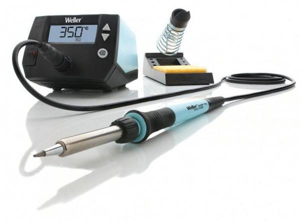 The image displays a soldering iron kit. It includes a digital temperature controller with a display, a soldering iron, and a stand with a sponge. The iron has a black handle and is silver-colored.