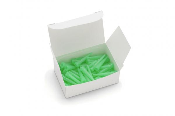 The image shows an open, white box filled with many small, green, cone-shaped objects. The objects are tightly packed and appear slightly transparent.