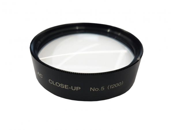 Das Bild zeigt einen runden Makro-Filter aus schwarzem Metall mit einer glatten, transparenten Glasoberfläche. Auf dem Filter steht "CLOSE-UP No.5" und eine Kennzahl. Der Filter dient zur Nahaufnahme in der Fotografie.