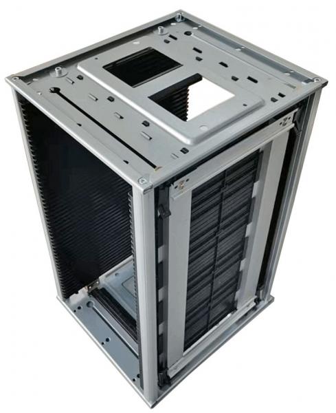 The image shows an open computer case made of gray metal. It has a rectangular shape with ventilation slots and multiple bays for components. The top is partially open.