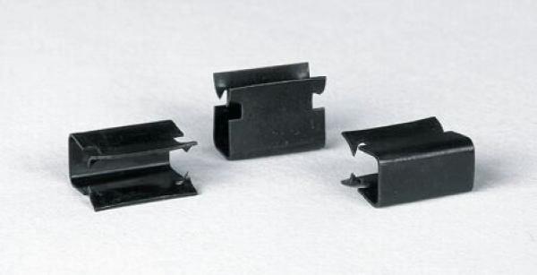 Auf dem Bild sind drei schwarze Metallklammern zu sehen. Sie haben eine ovale Form mit eingekerbten Seiten und einer Öffnung in der Mitte. Die Klammern liegen flach auf einer hellen Oberfläche.