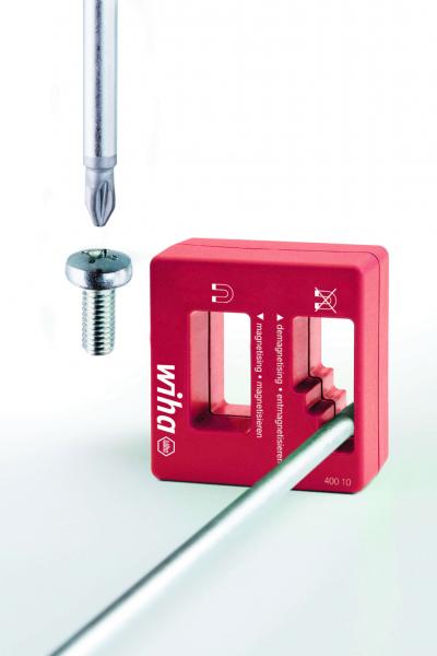 The image shows a red Wiha tool that has a fixture for screws. Next to the tool, a screw and a screwdriver are visible, floating in the foreground.