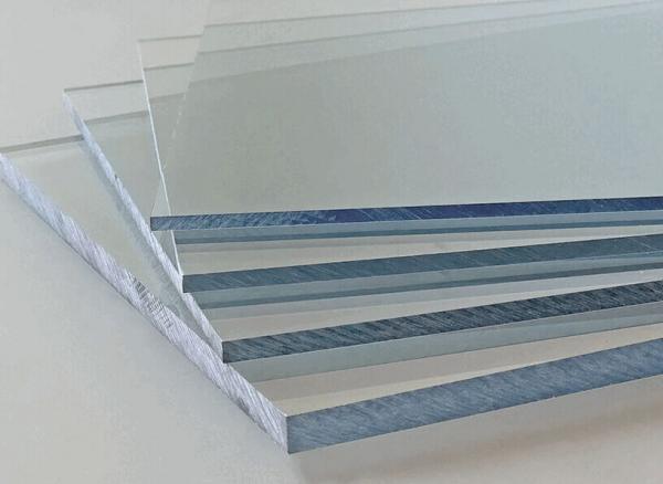 In the picture, several glass panes are stacked on top of each other. They are clear and reflect light, giving them a glassy, cool appearance. The edges are sharp.