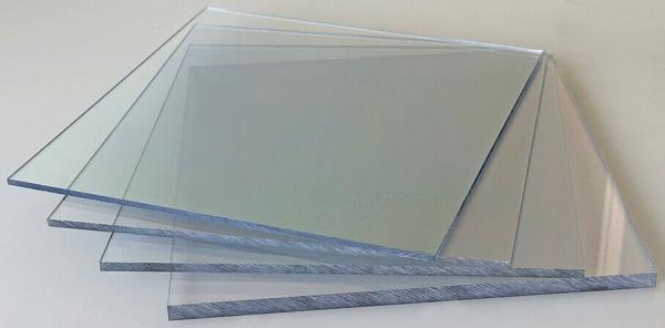 The image shows multiple transparent glass panes stacked on top of each other. The edges are slightly frosted, and they vary in size, arranged at a slight angle.