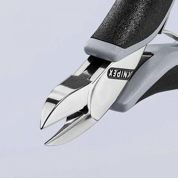 The image shows a high-quality nail scissors with shiny, sharp blades and ergonomic, gray rubber handles. It is designed for precise cutting.
