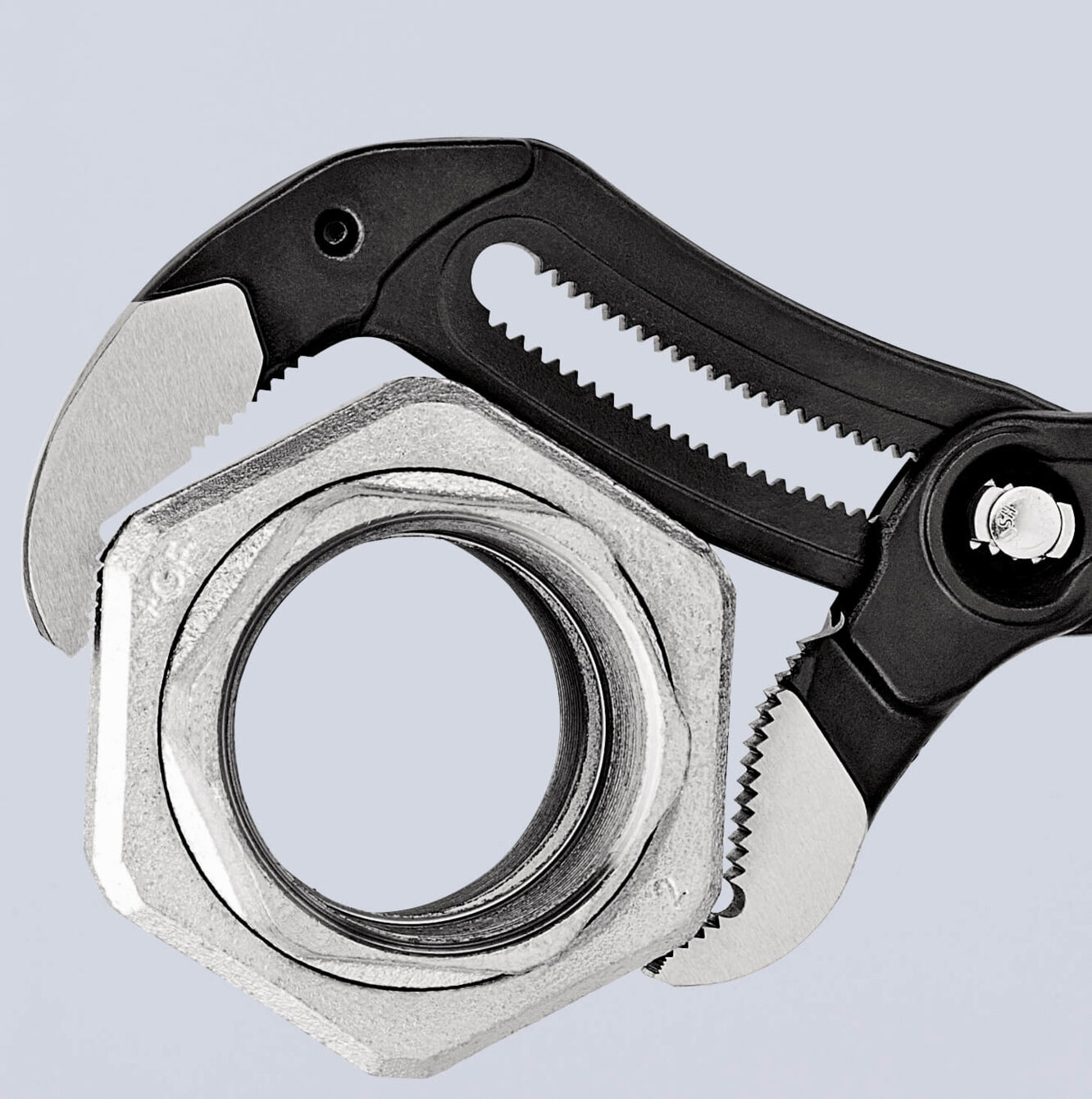 The image shows an adjustable wrench gripping a metal nut. The wrench has grippy, black handles and sharp teeth for better handling.