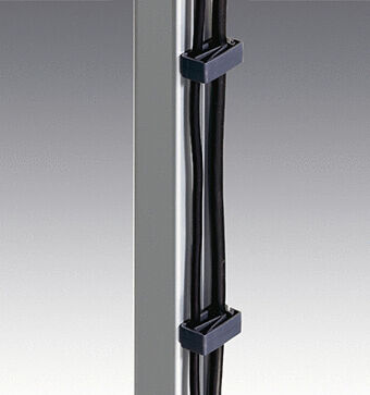 The image shows a vertical metal post with several black cables running along the side. These cables are attached to the post with black brackets.