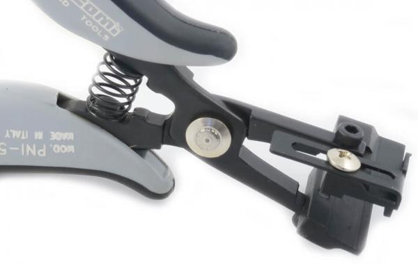 The image shows a gray pliers with a spring-loaded opening and a sturdy holder, used for precise work. One part is adjustable and includes screw locks.