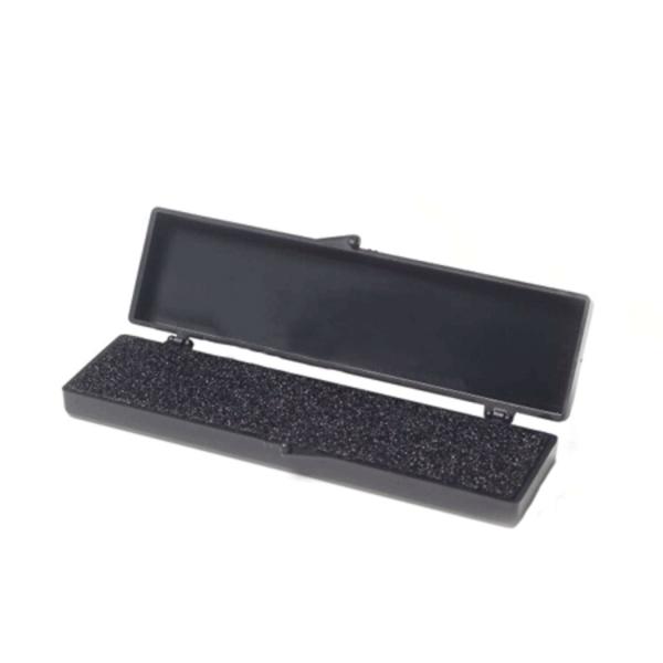 Das Bild zeigt eine schwarze, rechteckige Box. Sie hat einen Deckel, der aufklappbar ist. Im Inneren befindet sich eine strukturierte Oberfläche, die leicht gummiert erscheint.