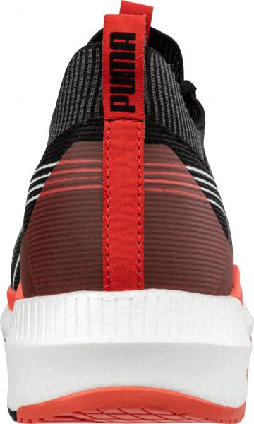 The image shows the rear view of a sporty shoe. It is black with red accents and has a white sole. There is a logo on the top and the structure is striped.