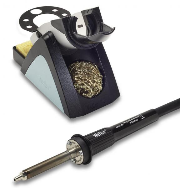 The image shows a soldering iron with a black cable and a soldering station. The station has a gray and black color scheme, a sponge, and a metal brush for cleaning the soldering iron.