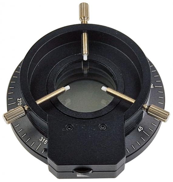 Das Bild zeigt ein schwarzes optisches Instrument mit einer runden Öffnung in der Mitte. Ränder sind mit Markierungen für Winkel versehen. Es hat zwei kleine Schrauben zur Justierung.