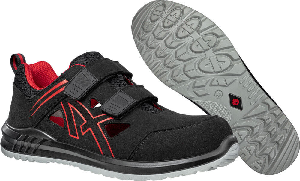 Das Bild zeigt ein Paar schwarze Schuhe mit roten Akzenten. Sie haben eine sportliche Form und Klettverschlüsse. Die Sohle ist griffig und hat ein strukturiertes Muster.