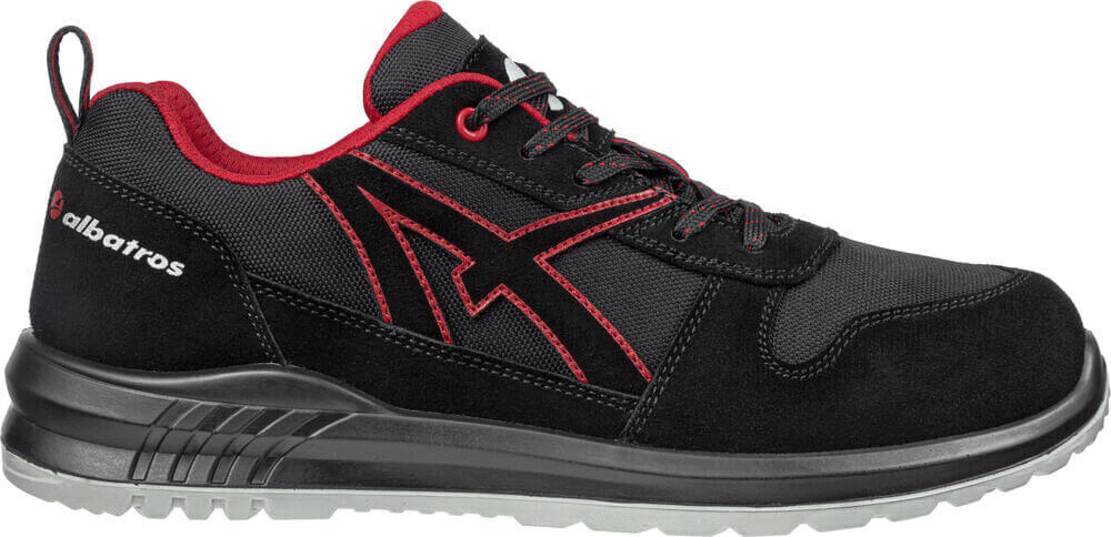 Der Schuh ist ein sportlicher Halbschuh in Schwarz mit roten Akzenten. Er hat eine rutschfeste Sohle, Schnürsenkel und eine gepolsterte Innensohle für Komfort.