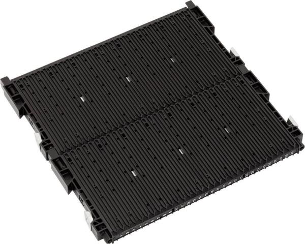 Das Bild zeigt eine schwarze, flache Kunststoffplatte mit mehreren parallel verlaufenden Rillen und Aussparungen. Sie hat an den Ecken Befestigungselemente und ist rechteckig geformt.