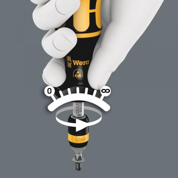 The image shows a screwdriver with a yellow and black handle, held by a hand. At the head of the screwdriver, there is a scale from 0 to 8 for torque adjustment.