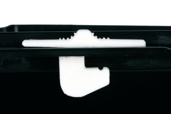 The image shows a black plastic container with a white closure mechanism. The closure has a curved shape and a straight edge.