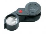 Preview: The image shows a handy magnifying glass with an adjustable, round glass area. It has a black plastic frame and a red button. The magnification is 10x.