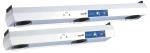 Preview: The image shows two elongated, silver ventilation devices. Each has a blue control area with buttons and symbols. The devices are arranged one above the other. They are designed to be sturdy and functional.