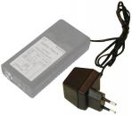 Preview: The image shows a gray power supply with a label on the top. It has a long cable and a small plug for an outlet. The shape is rectangular and compact.