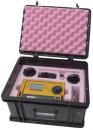 Preview: The image shows an open, black suitcase with a foam-padded interior. Inside, there is a yellow device with a display, buttons, and additional accessories.
