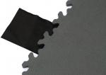 Preview: The image displays a matte, green surface with a jagged edge, next to which lies a piece of black fabric. The mat has a textured surface that appears to be slip-resistant.