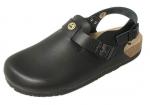 Preview: The image shows a black clog shoe. It has a closed front, a wide heel, and an adjustable strap at the back. The sole is sturdy and made of a dark material.