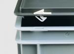Preview: The image shows stackable, rectangular containers in gray and light gray with a lid. A small white clip on a lid is visible, which serves as a fastener.