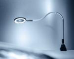 Preview: The image shows a flexible desk lamp with a round, magnifying light. The neck of the lamp is bendable and it stands on a stable, black base. The background is in soft shades of gray.