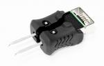 Preview: Das Bild zeigt einen schwarzen Adapter mit einem USB-Stecker an einem Ende und zwei Stiften am anderen Ende. Der Adapter hat eine gummierte, strukturierte Oberfläche für besseren Halt.