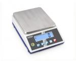 Preview: The image shows a digital scale with a smooth, rectangular metal surface. Below it, there is a display with blue digits and several buttons for operation.