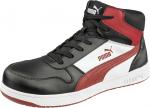 Preview: Der Schuh ist ein halbhoher Sneaker mit einer schwarzen Lederoberfläche. Er hat rote und weiße Akzente sowie eine robuste, weiße Sohle. Schnürsenkel und das Puma-Logo sind ebenfalls sichtbar.