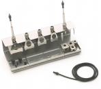 Preview: The image shows a metallic tool set with several holders and connections. There are three upright elements and a cable connection that runs sideways. The surface is flat.