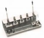 Preview: The image shows a metallic component with four vertical supports and various openings. It has a flat base and some rectangular and square elements for attachment.