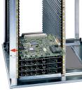 Preview: Das Bild zeigt einen vertikalen Computer-Rack mit mehreren grün gestrichenen Platinen. Die Platinen sind in einem Metallgehäuse gestapelt, versehen mit mehreren Anschlüssen und Steckplätzen.