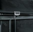 Preview: The image shows a dark, square plastic container. On the top, there is a clip closure that secures the lid. The bottom has some structural lines and indentations.