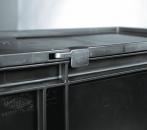 Preview: The image displays a black plastic container with a flat lid. A small metal clasp is visible on the side. The container features a sturdy, rectangular design.