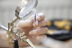Preview: In the image, a hand is visible holding a fine pair of tweezers. A magnifying glass is attached to a holder. Tools are visible in the background. The atmosphere is crafty.