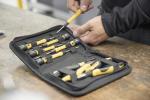 Preview: The picture shows a tool bag with several screwdrivers. The tools have gray handles with yellow accents. A hand is holding a screwdriver while the bag is on a table.