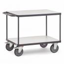 Preview: Ein zweistöckiger Servierwagen mit einem stabilen, grauen Metallrahmen. Er hat zwei Ebenen mit glatten, hellen Oberflächen und vier beweglichen, großen Rädern für einfache Mobilität.