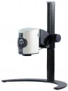 Preview: The image shows a compact projector with a white casing, mounted on a black, sturdy stand. The projector has control buttons on the front.