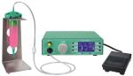 Preview: The image shows a green painted device with a display that shows settings. Next to it is a container with pink liquid. A foot pedal and hoses are connected.