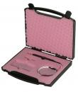 Preview: The image shows an open black suitcase with a pink foam interior. Inside are several tools and a circular object. The suitcase has a handle.